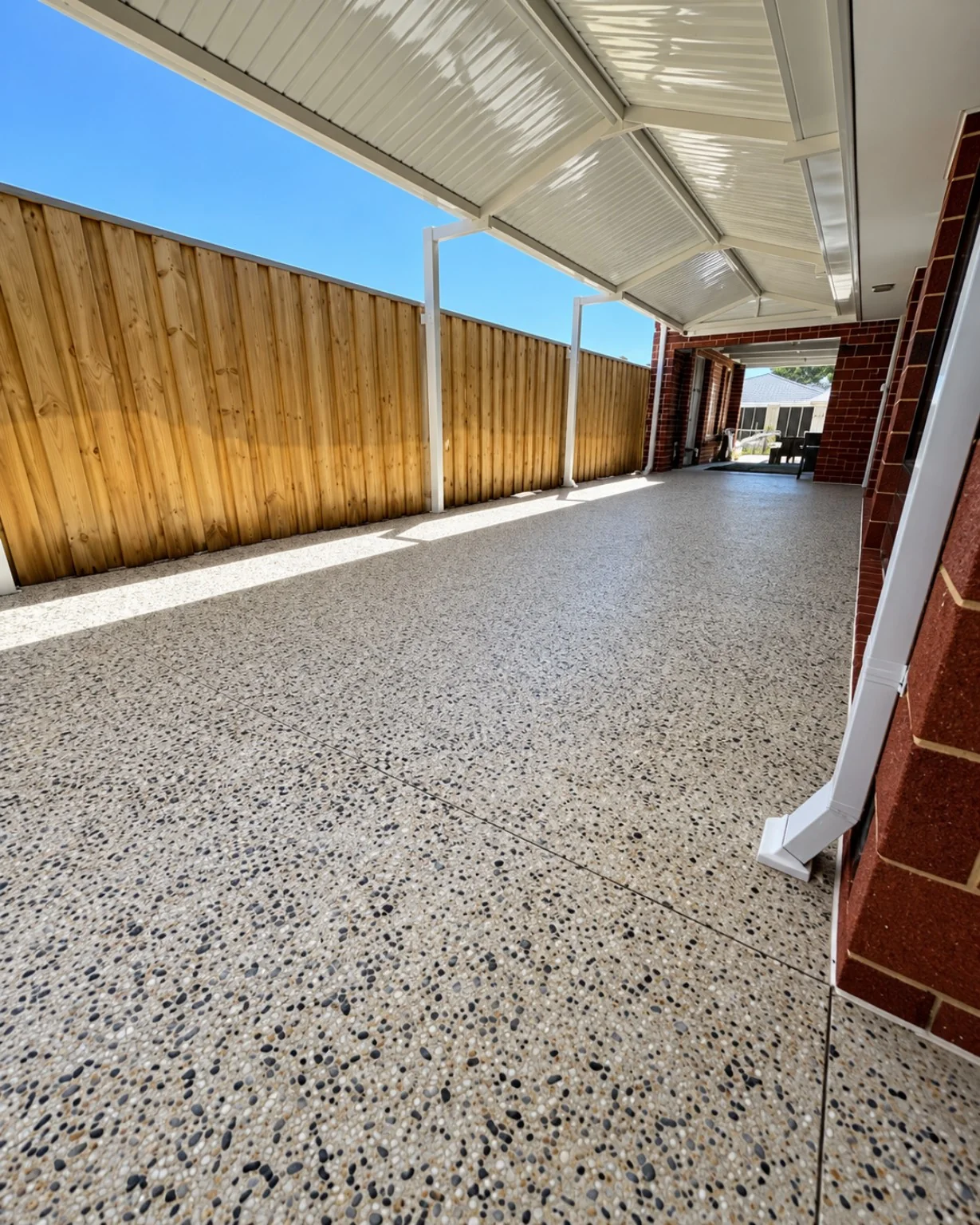 Exposed aggregate concrete finish below a covered alfresco and carport