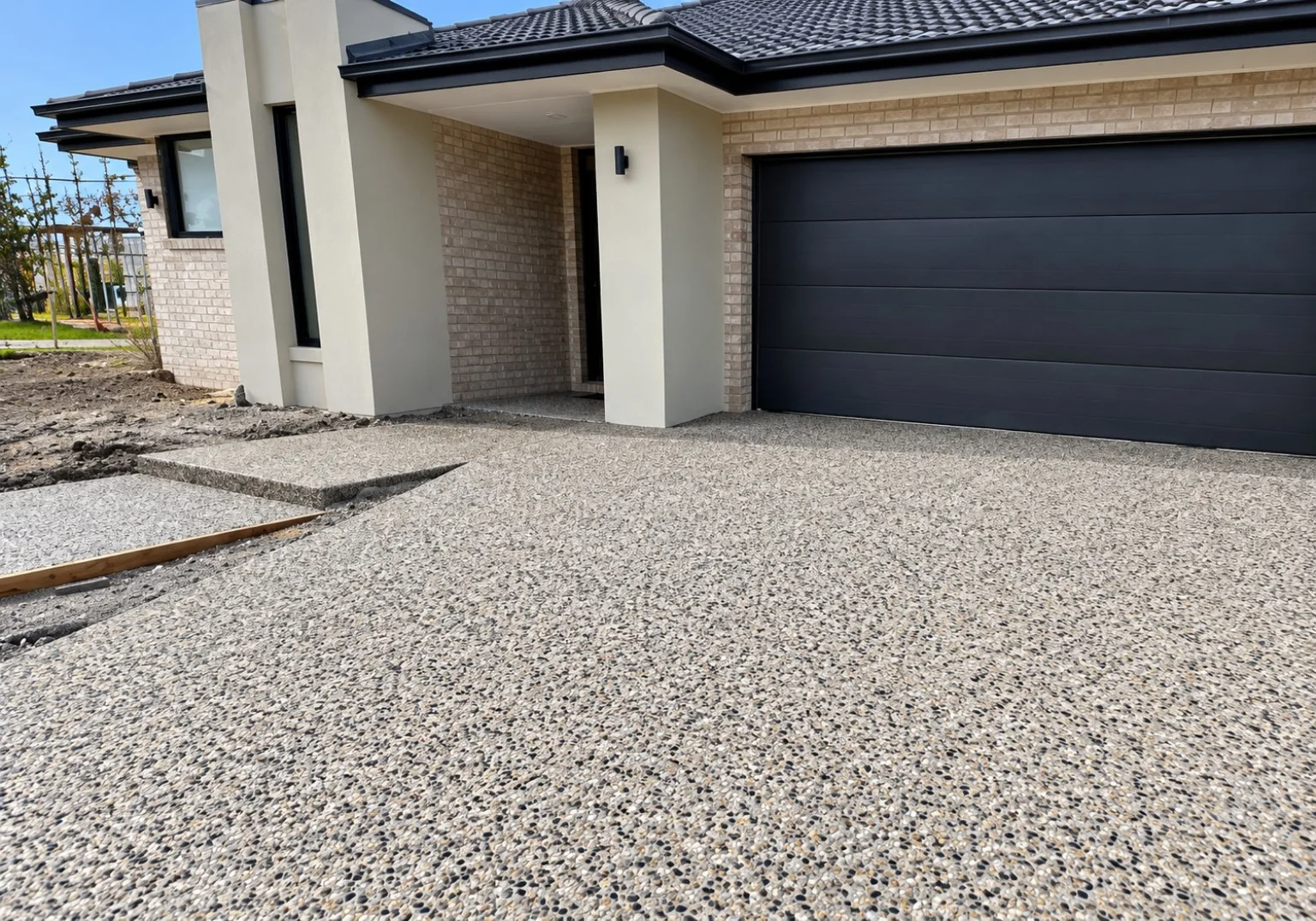 Exposed aggregate driveway outside a modern home